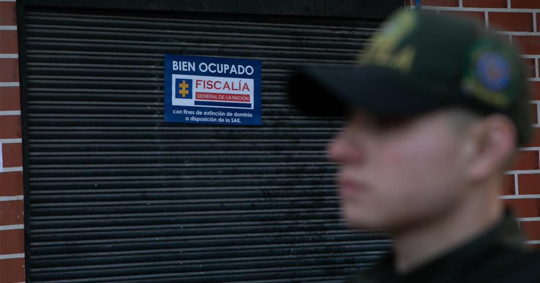 Imagen de un policía borroso y de fondo un local sellado