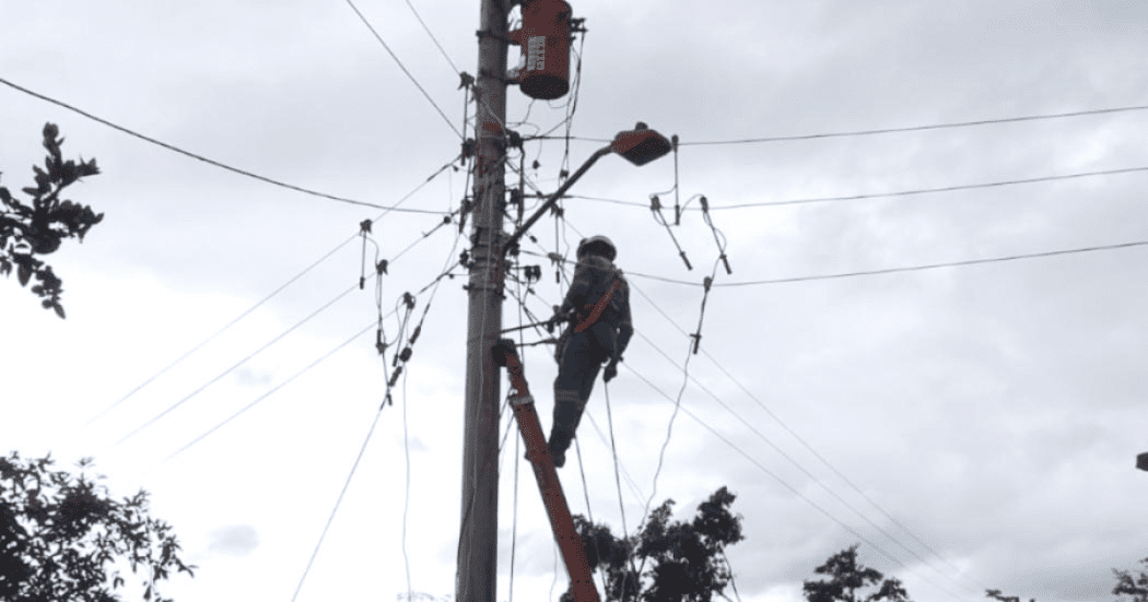 Imagen de un técnico de ENEL ralizando mantenimiento en un poste de luz.