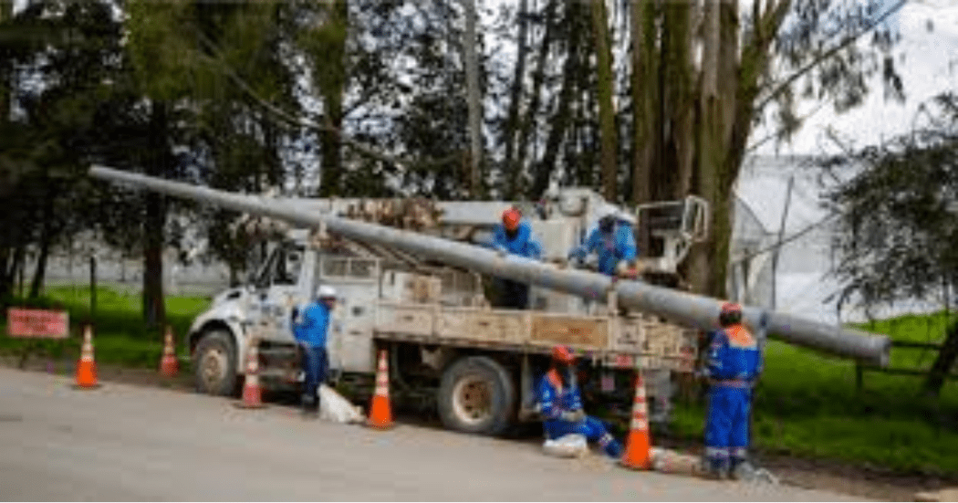 Imagen de varios trabajadores de ENEL manipulando material en un carro en el que realizan su trabajo.