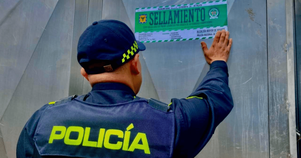 Imagen de un Policía poniendo un letrero de sellamiento