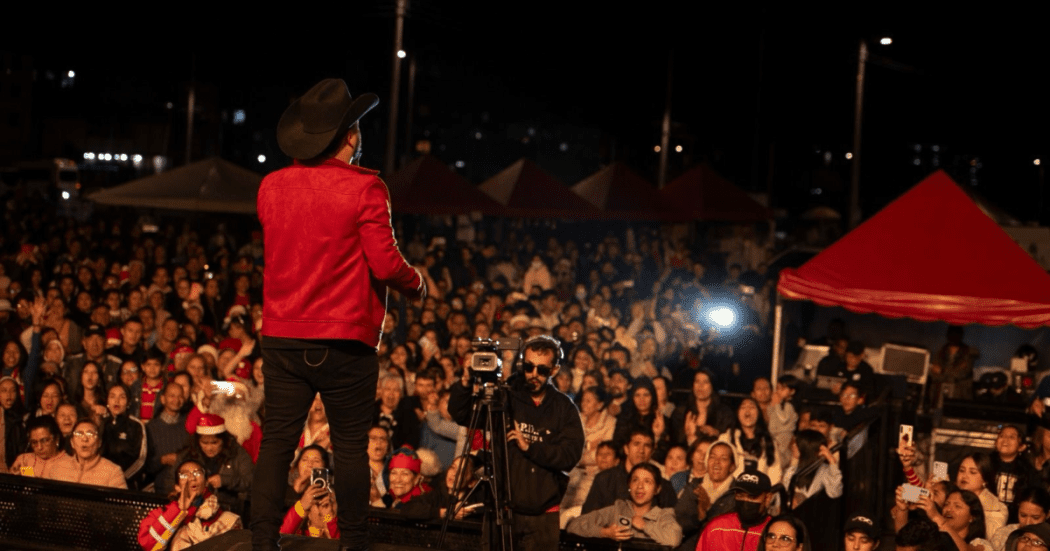 Imagen de un artista cantando en el escenario ante decenas de personas