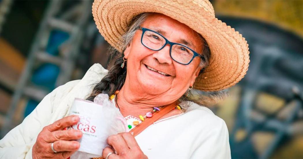 En la foto una mujer de la tercera edad feliz y tomando café