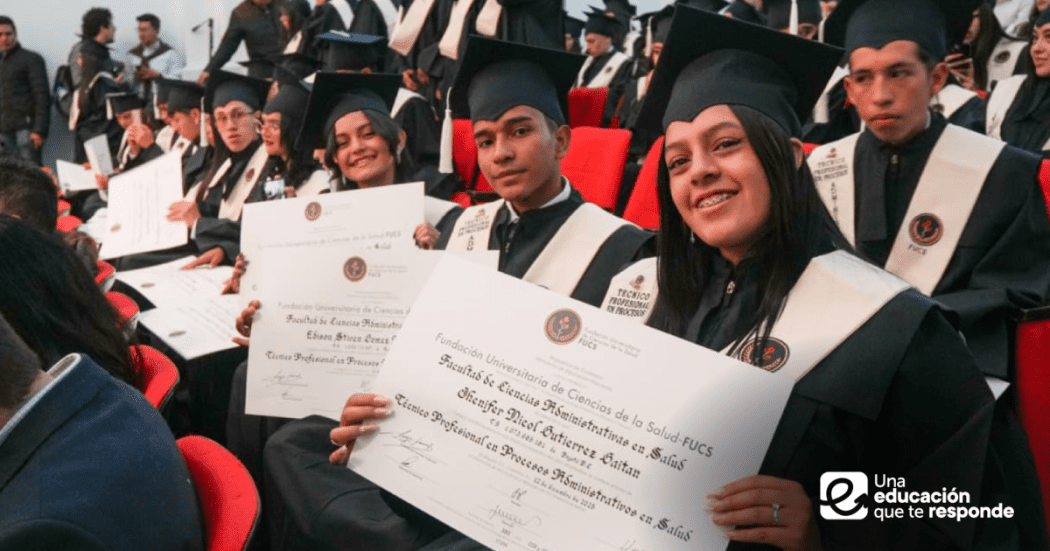 Imagen de estudiantes alzando sus diplomas de grado