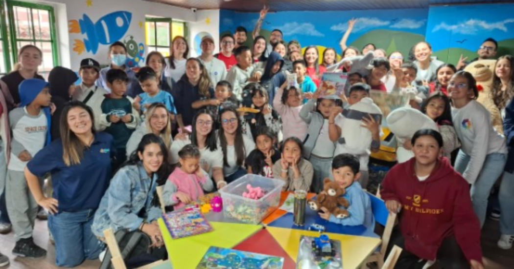 Imagen de niños, niñas y voluntarios posando para la foto en la Ludoteca.