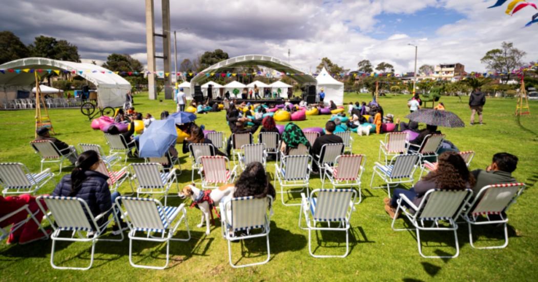 Foto que muestra personas sentadas en sillas en un parque