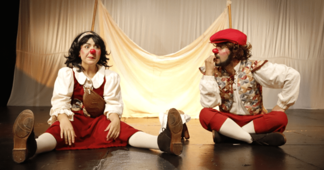 Imagen de dos payasos vestidos de rojo con blanco en escena.