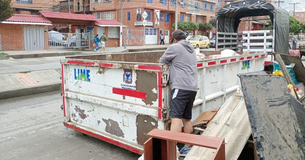 Foto que muestra una persona colocando residuos en un ecopunto 
