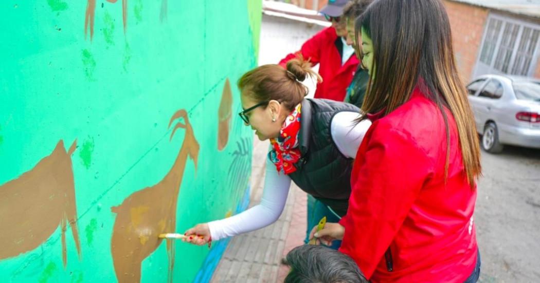 Foto que muestra personas pintando una pared