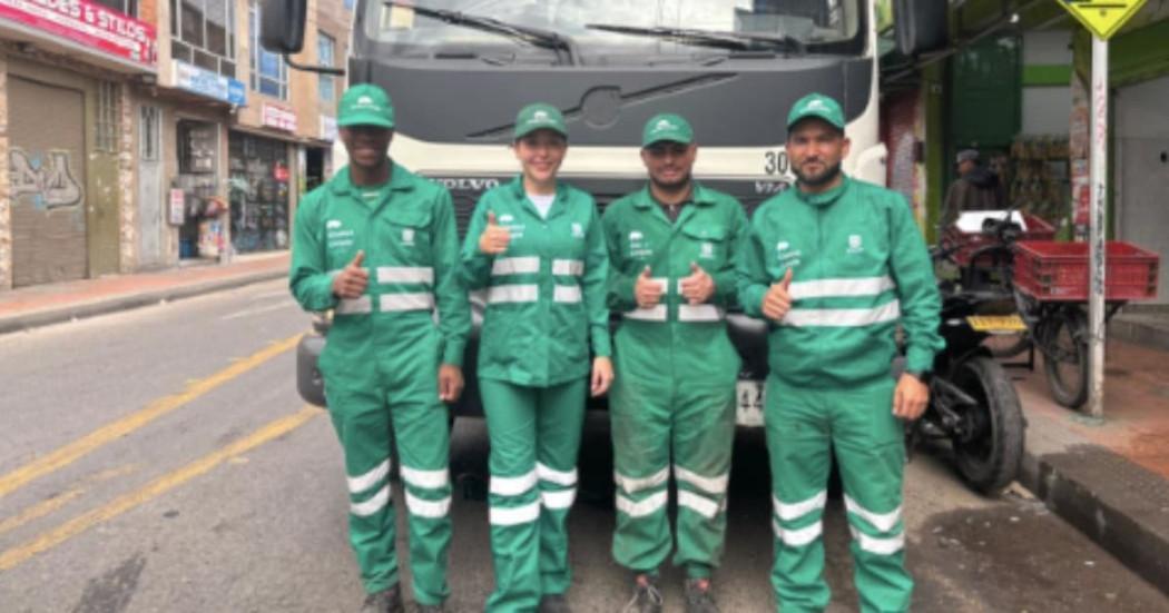 Foto de un grupo de operarios y operarias de aseo en Bogotá, al lado un camión recolector de basuras.