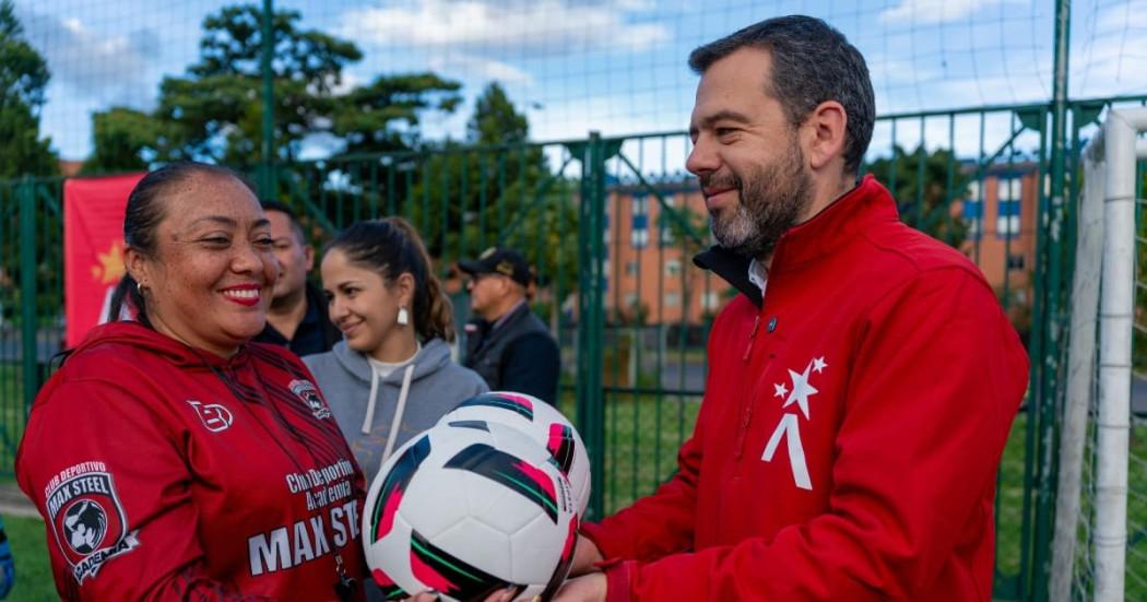 Foto del alcalde Carlos Fernando Galán junto a una mujer durante la entrega de cinco canchas de fútbol y rugby renovadas en Fontibón.