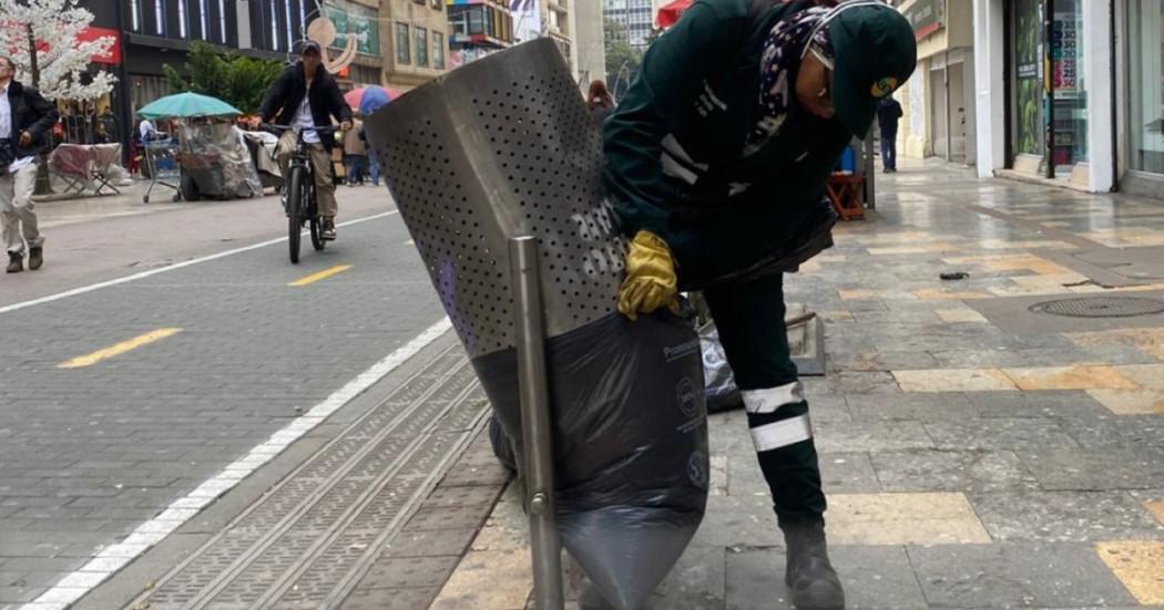 Foto que muestra una persona sacando basura de una caneca