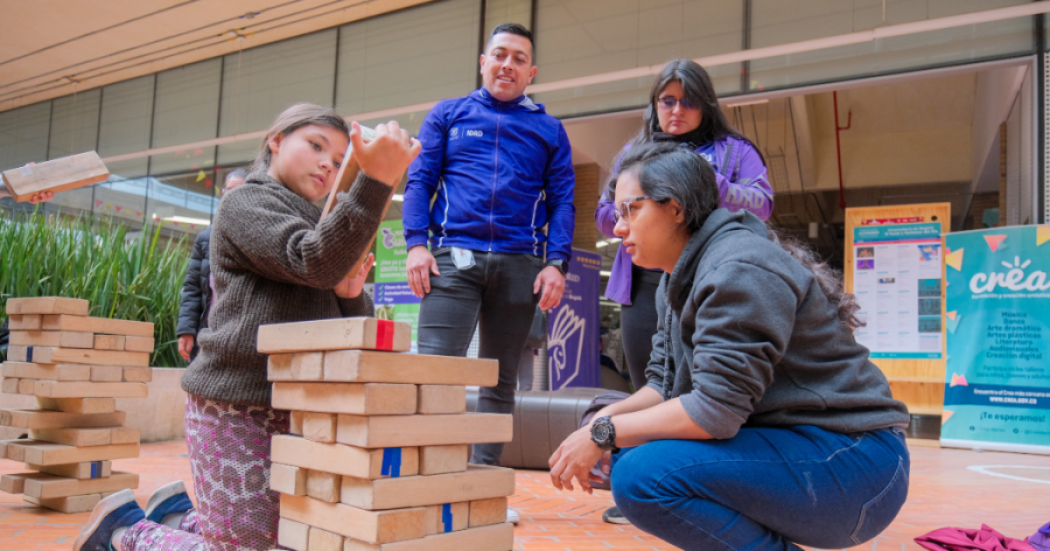 Imagen de personas y funcionarios del IDRD interactuando con niño.