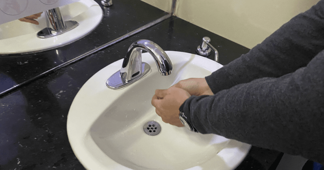 Foto que muestra una persona lavándose las manos