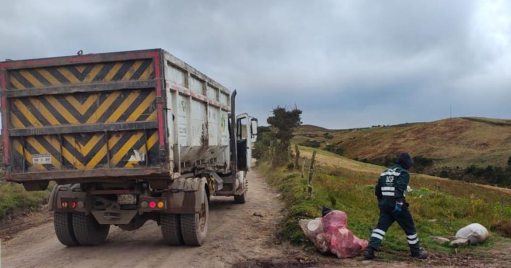 Foto que muestra una volqueta y un trabajador recolectando residuos