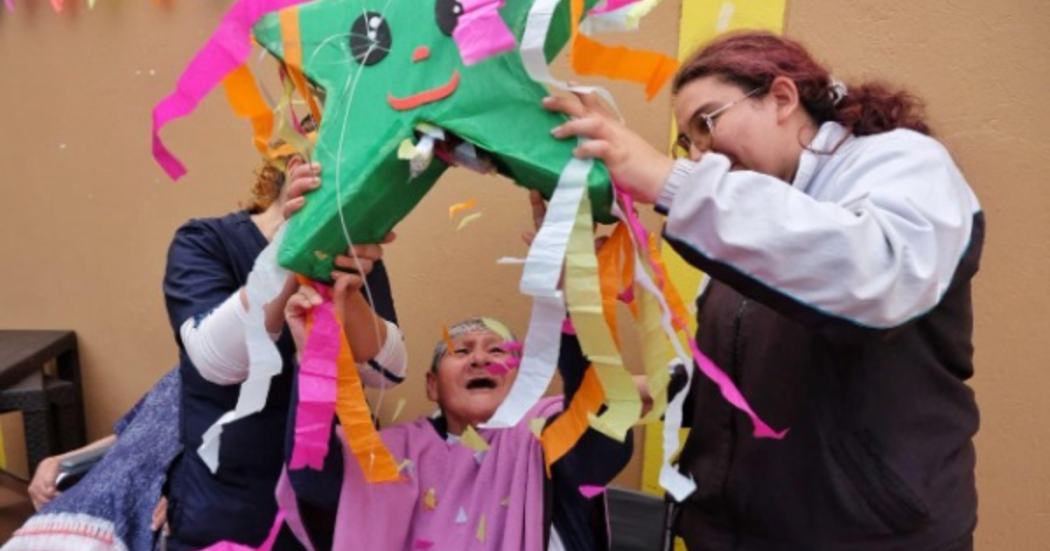 Imagen de una persona mayor sonriendo junto con otras dos personas