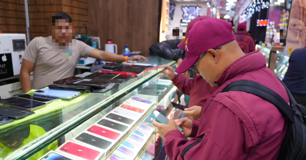 Imagen de un funcionario de la secretaría de seguridad revisando un celular