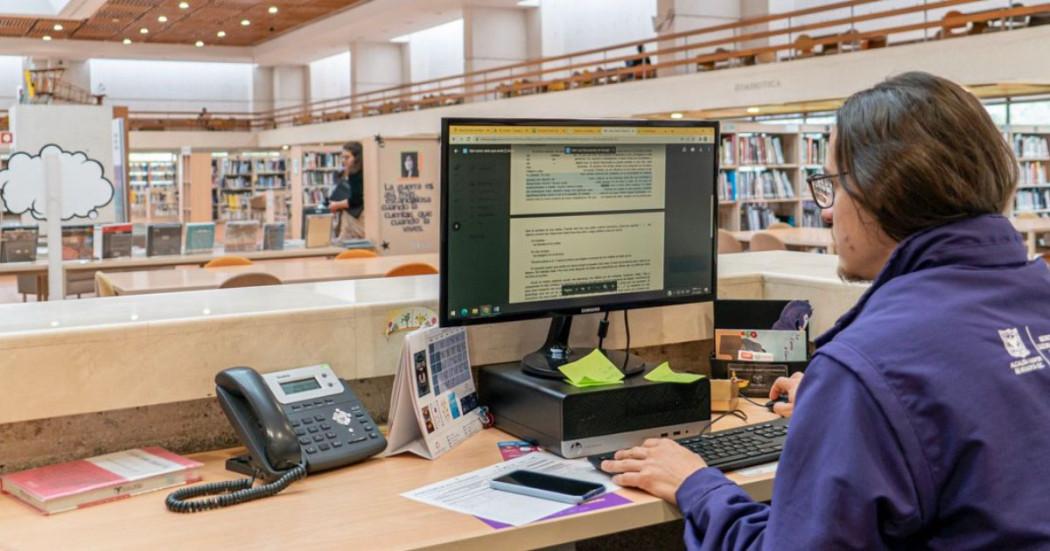 Imagen de funcionario de BibloRed trabajando en un computador