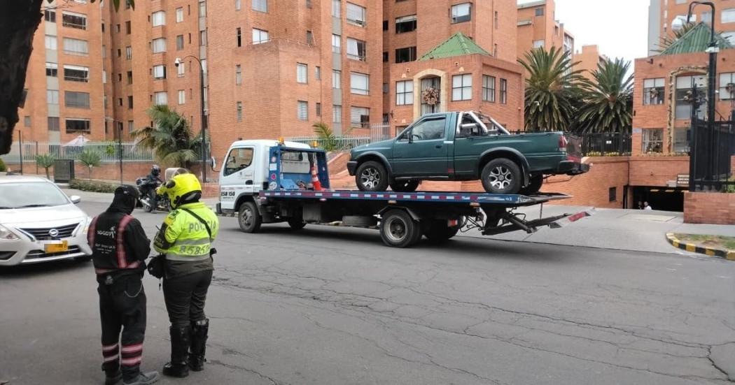 Foto de un agente de tránsito junto a una grúa