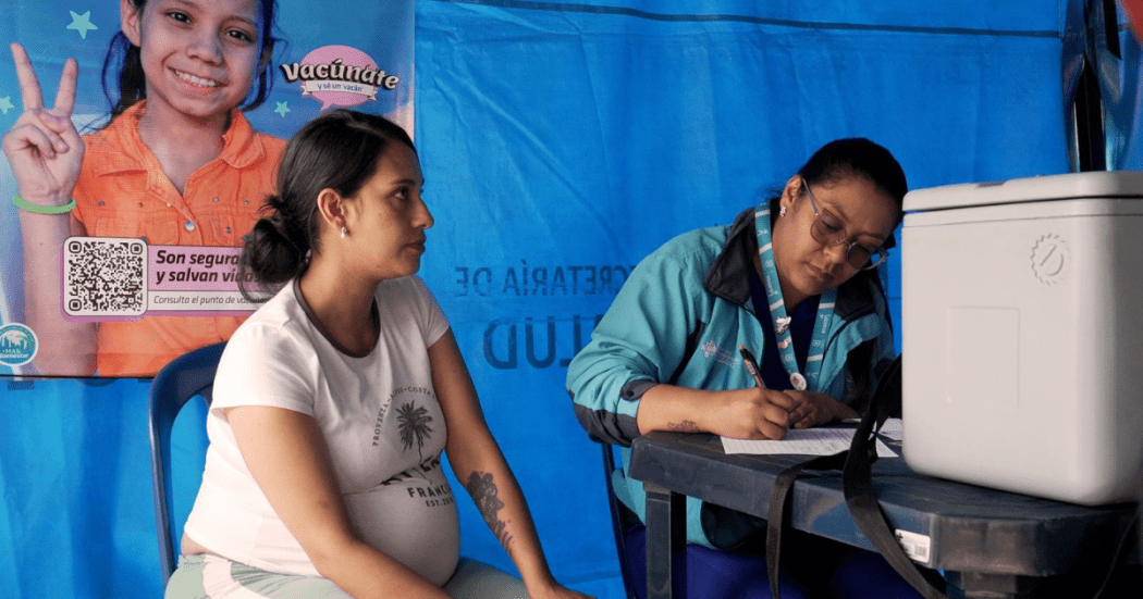 Foto de una enfermera colocando una vacuna en el hombro de una persona