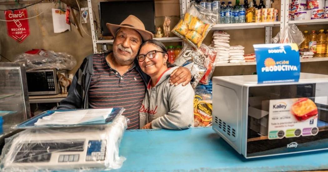 Fotos de dos campesinos de Sumapaz, recibiendo ayudas de 'Evolución Productiva’. 