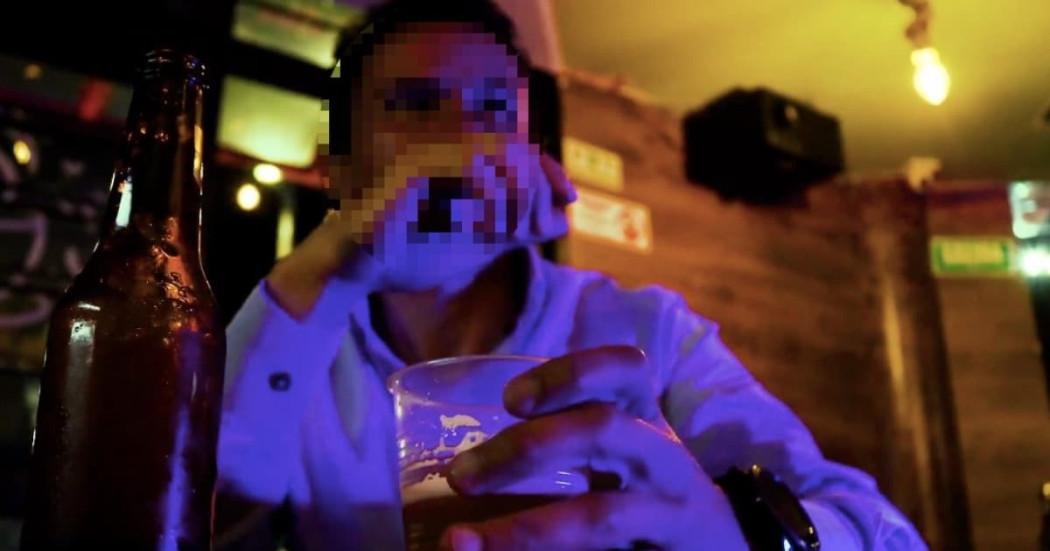 Foto de un hombre en un establecimiento nocturno consumiendo una bebida.