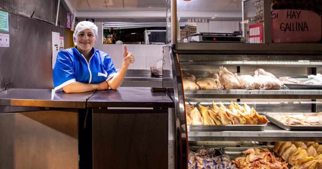 Foto de una comerciante y su negocio.