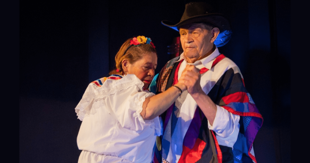 Imagen de una mujer y un hombre adultos mayores bailando con trajes típicos.