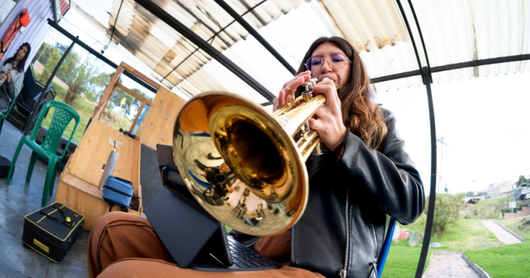 Imagen de una mujer jóven tocando un instrumento músical de viento.