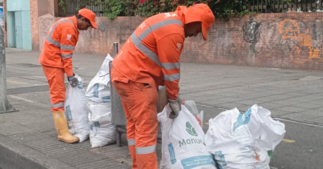 Foto que muestra dos personas recogiendo residuos en la calle 