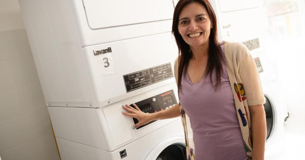 mujer al lado de una lavadora 