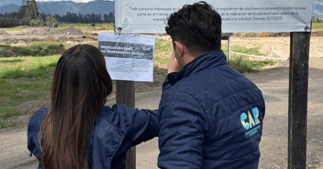 Imagen de dos personas de la CAR sellando el predio