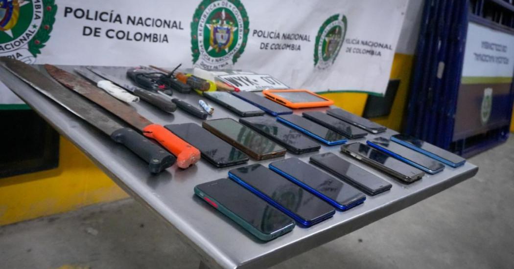 Foto que muestra celulares y armas sobre una mesa 