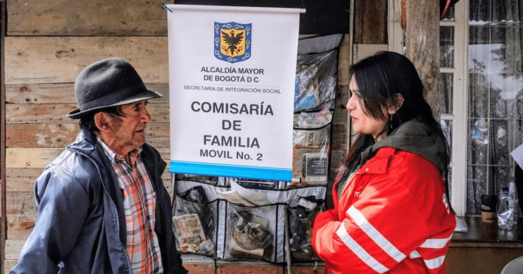 Imagen de una funcionaria de Integración Social junto a un adulto mayor