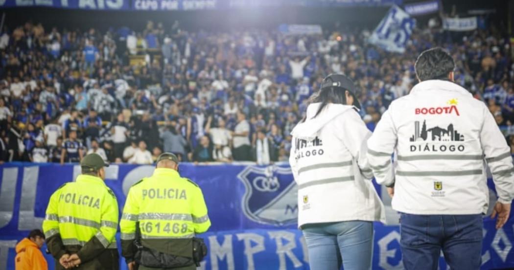 Gestores de diálogo y policías con barra de Millonarios de fondo