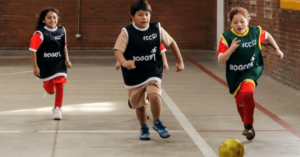 Imagen de tres niños jugando fútbol
