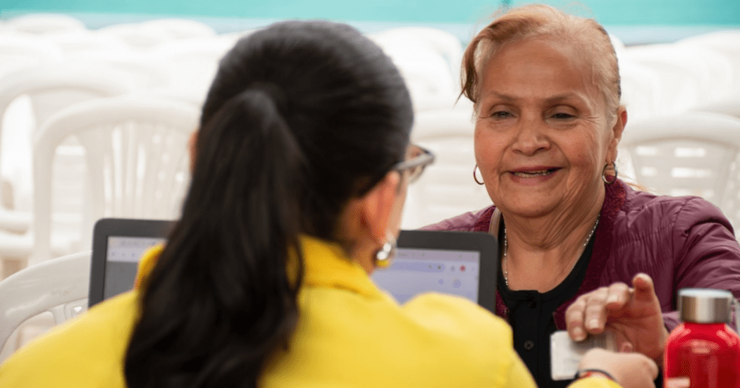 Imagen de una funcionaria atendiendo a una adulta mayor