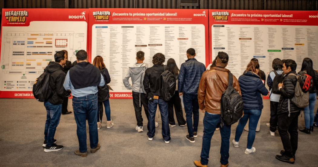 Imagen de varias personas viendo carteles con información de empleo