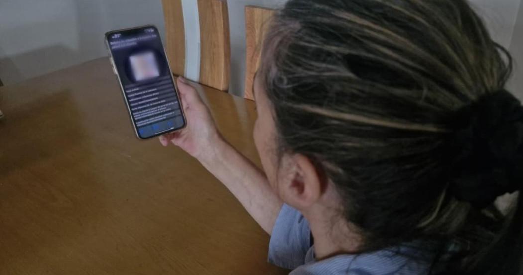 Mujer viendo celular con mensaje de texto fraudulento