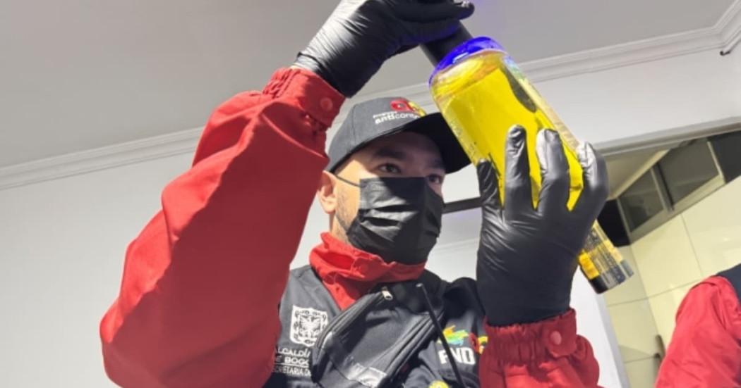 Foto de un funcionario realizando verificación de botellas de licor durante los controles en el centro de Bogotá.