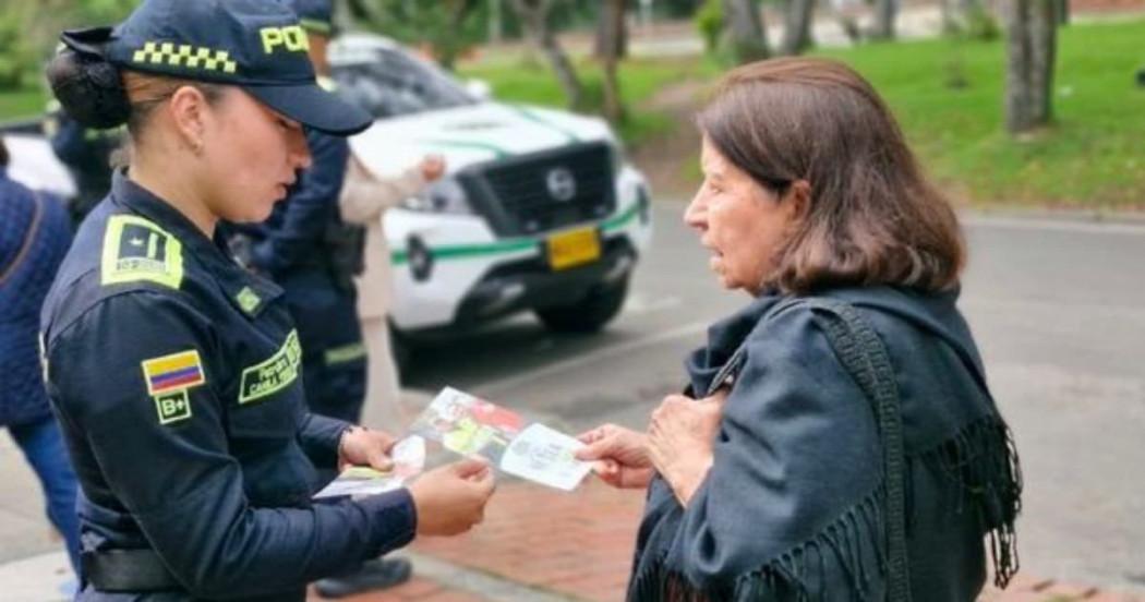 Uniformada de la Policía entregando información a ciudadana.