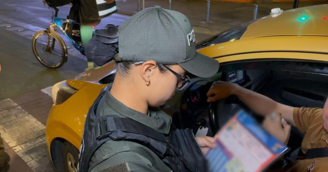 Uniformada de la policía verificando un taxi para el servicio