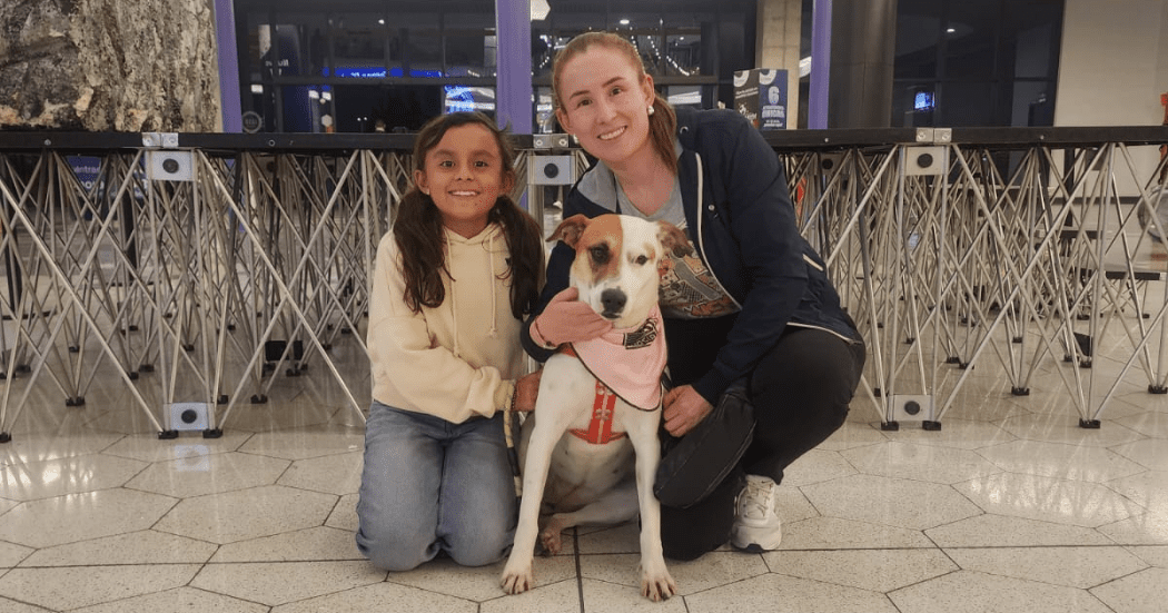 Imagen de una señora con una niña y una perrita recién adoptada