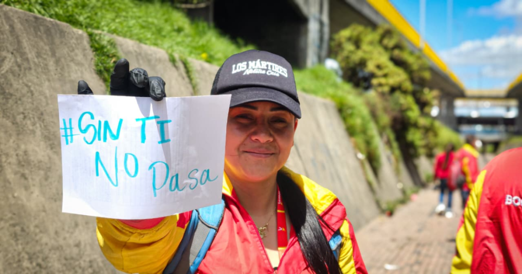 Foto de una funcionaria del Distrito con un cartel 