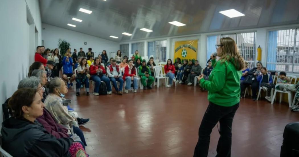 Foto que muestra un grupo de personas reunidas en un salón 