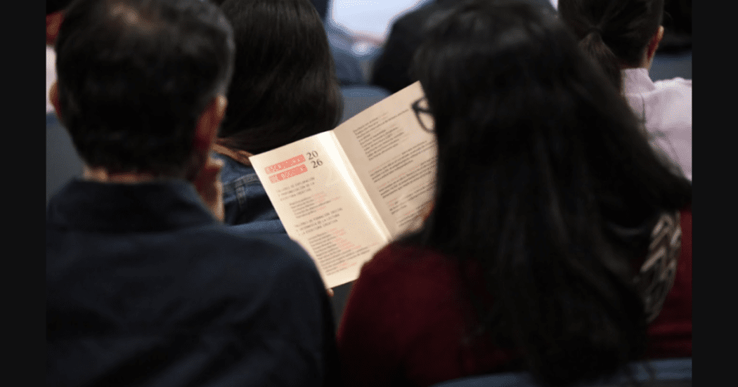 Imagen de un hombre y una mujer sentados leyendo un libro.