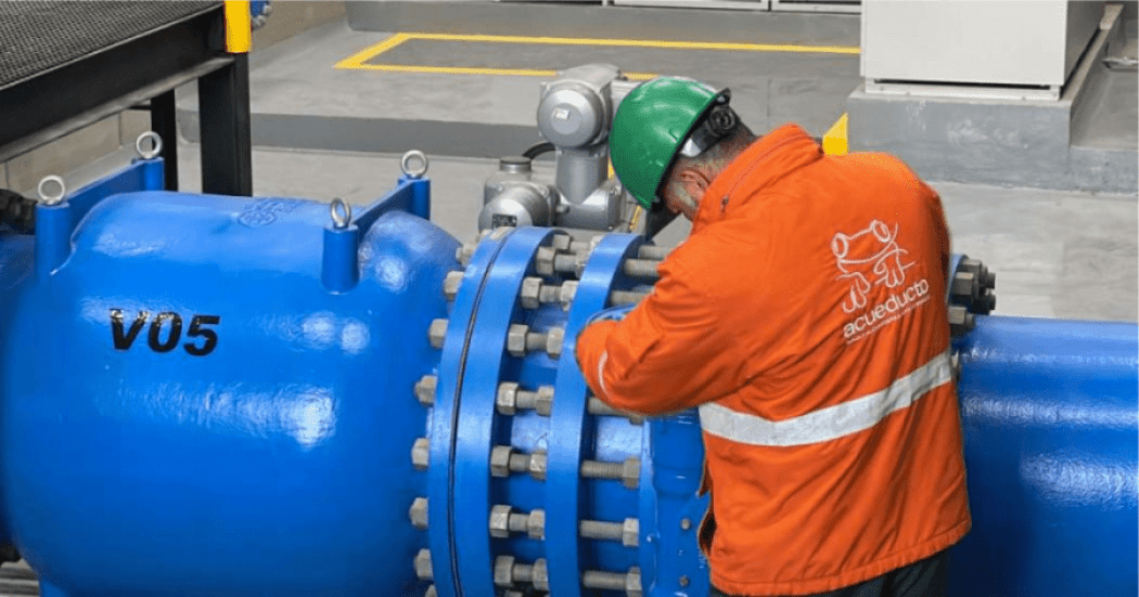 Imagen de un técnico de la empresa de Acueducto realizando mantenimiento en un tubo de alcantarillado.