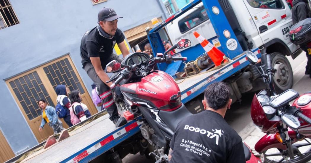 Contratistas subiendo una moto a una grúa 