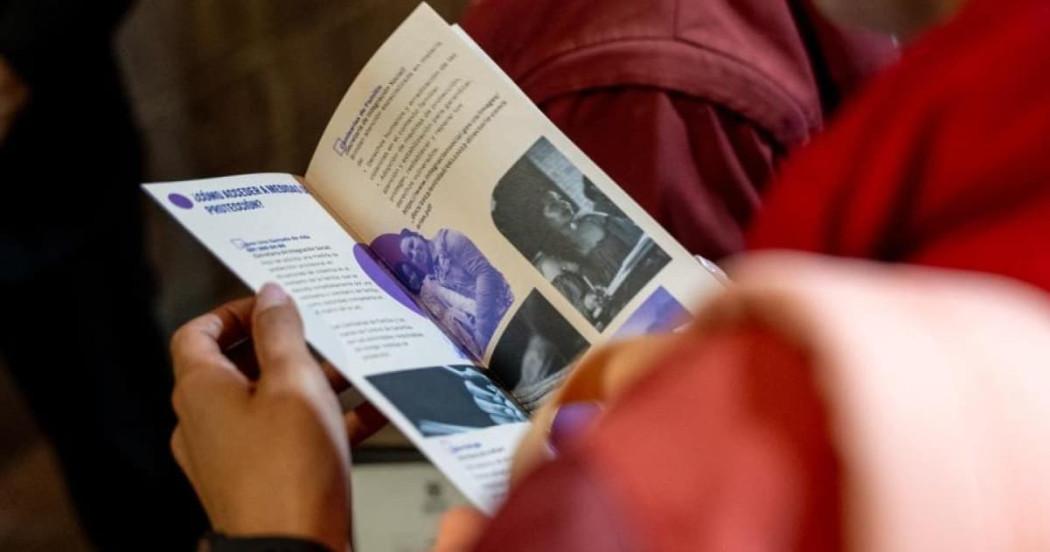 Manos de mujer sosteniendo un folleto de la SDMujer sobre cómo acceder a medidas de protección