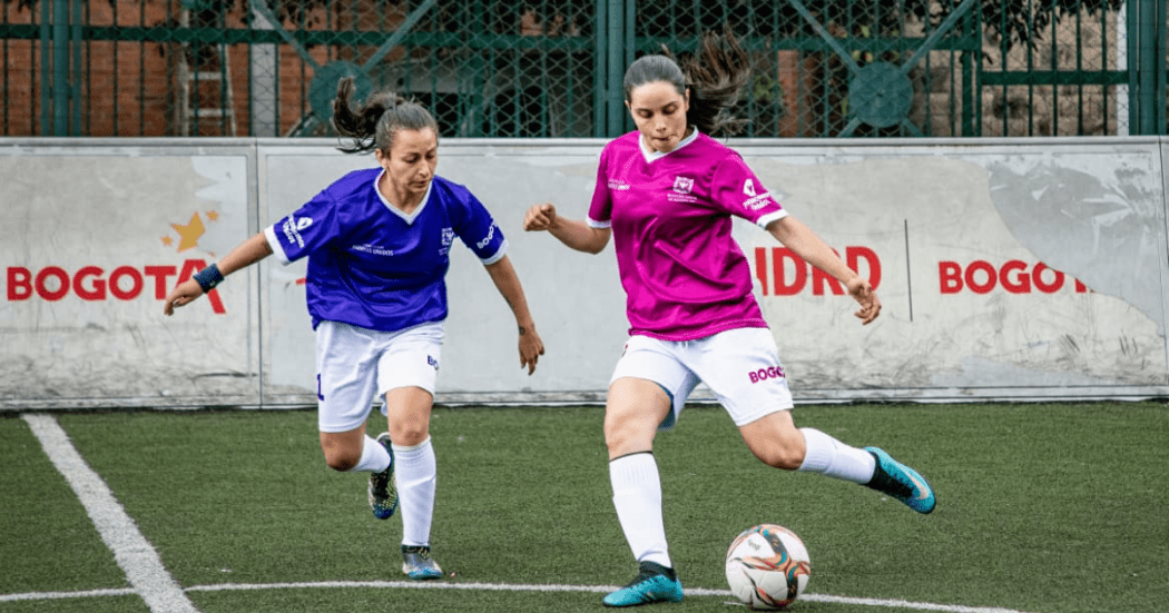 Foto de dos mujeres jugando fútbol