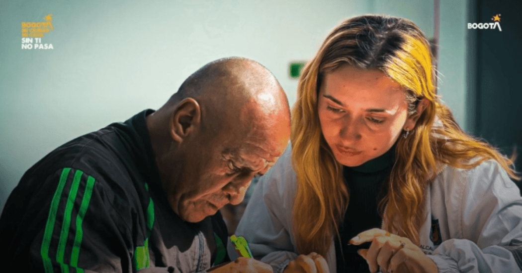 Foto de una funcionaria del Distrito ayudando a un ciudadano 
